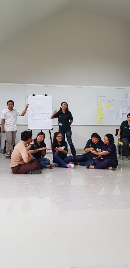 A gray heart shaped stone sits atop a mossy mound on a city park road.